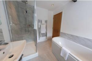 ein Bad mit einer Badewanne, einer Dusche und einem Waschbecken in der Unterkunft Bert's Rooms at The Black Horse Inn in Brighouse