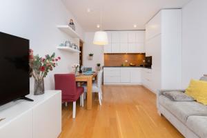 Una cocina y una sala de estar con un sofá y una mesa. en Nadmorski Apartament z Parkingiem Gdynia Redłowo by Noclegi Renters, en Gdynia