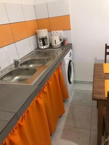 a kitchen with a sink and a washing machine at Appartement T1 in Saint-Laurent du Maroni