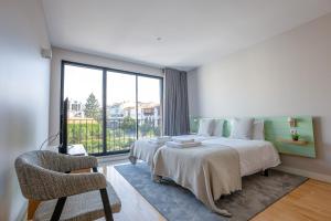 a bedroom with a bed and a large window at Oporto Trendy Formosa in Porto