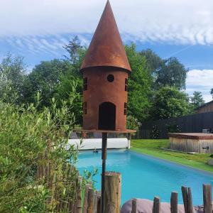 una casa de aves sentada junto a una piscina en Gîte des Lavandières en Amanlis