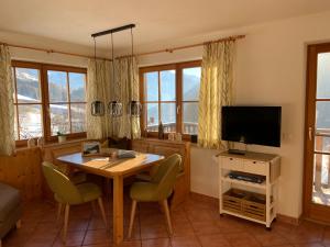 a living room with a table and a television at Virgenhaus in Virgen