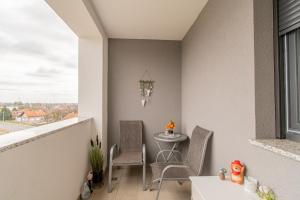 einen Balkon mit einem Tisch und Stühlen sowie einem Fenster in der Unterkunft Flexible SelfCheckIns 42 - Zagreb - Luxury - Garage Parking - Loggia - Brand New in Zagreb