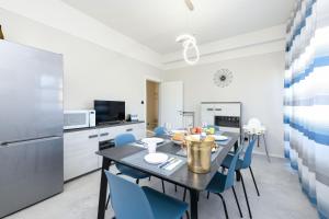 My Desenzano Family Apartment في ديسينسانو ديل غاردا: مطبخ وغرفة طعام مع طاولة وكراسي