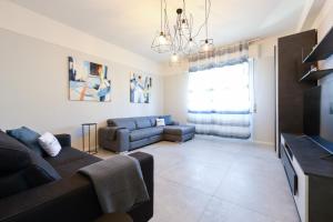 My Desenzano Family Apartment في ديسينسانو ديل غاردا: غرفة معيشة مع أريكة وتلفزيون