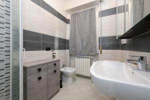 My Desenzano Family Apartment في ديسينسانو ديل غاردا: حمام مع حوض وحوض استحمام ومرحاض +30 صورة