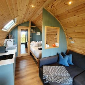 a room with a couch and a bed in a house at Odli Glamping - Luxury Glamping Pod in Welshpool