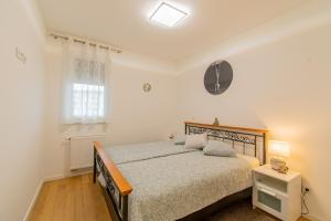 ein weißes Schlafzimmer mit einem Bett und einem Fenster in der Unterkunft Flexible SelfCheckIns 42 - Zagreb - Luxury - Garage Parking - Loggia - Brand New in Zagreb