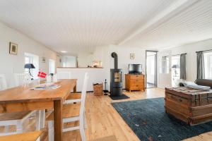 Skovby 1 في Skovby: غرفة معيشة مع طاولة خشبية وموقد