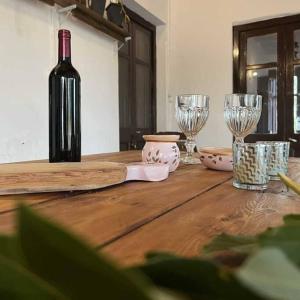 a wooden table with a bottle of wine and glasses at Uruguay Casa de Época Campestre in Mercedes