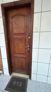 a wooden door in a room with a tile wall at Tranquilidade in Rio de Janeiro