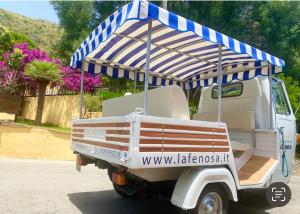 a golf cart with an umbrella on the back at Villaggio Turistico La Fenosa in Marina di Camerota