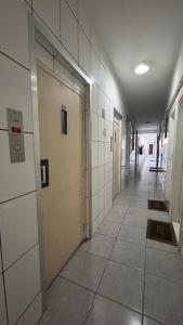 an empty hallway of a building with doors and tiles at Tranquilidade in Rio de Janeiro