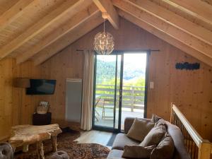 a living room with a couch and a large window at Le Chalet de Juliette in Gérardmer