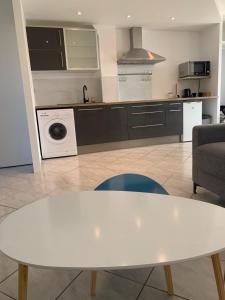 a kitchen with a white table in a kitchen at Appartement moderne près de Toulouse in Fonsorbes +3 photos