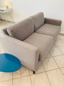un sofá en una sala de estar con una mesa azul en Appartement moderne près de Toulouse, en Fonsorbes