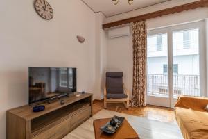 a living room with a large flat screen tv at Studio Mélange in Loutraki DT in Loutraki
