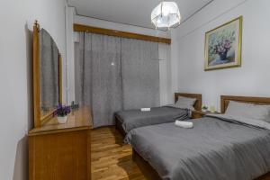 a bedroom with two beds and a mirror at Studio Mélange in Loutraki DT in Loutraki