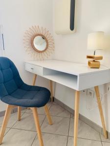 Fonsorbes的住宿－Appartement moderne près de Toulouse，一张带蓝色椅子和镜子的桌子