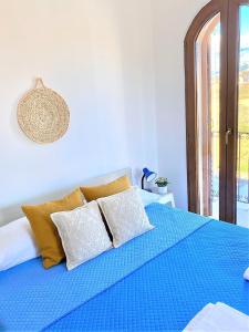 un letto con lenzuola e cuscini blu in una stanza di Porto Frailis 2 a Tortolì