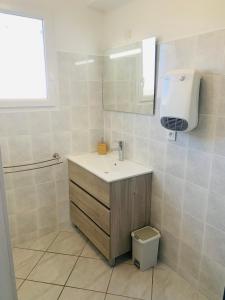 W łazience znajduje się umywalka, lustro i toaleta. w obiekcie Appartement moderne près de Toulouse w mieście Fonsorbes
