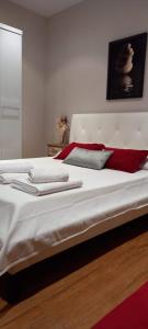 een bed met rode en witte kussens erop bij Villa Alba cerca de Sitges in Canyelles