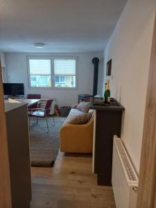 salon z żółtą kanapą i stołem w obiekcie Ferienhaus Am-moore w mieście Steindorf am Ossiacher See