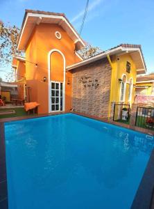 una gran piscina azul frente a una casa en บ้านสามหมา pool villa เขาใหญ่, en Ban Pang Asok