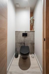 a bathroom with a black toilet in a hallway at Appart de standing - Centre-ville in Chalon-sur-Saône