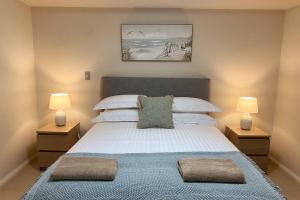 - une chambre avec un grand lit et deux lampes dans l'établissement Bannister Apartment in vibrant central Fremantle, à Fremantle