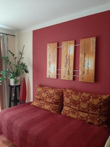 a bedroom with a purple wall with paintings on it at City terrace-apartment in Vienna