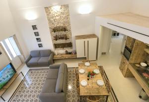 een woonkamer met een bank en een tafel bij Dione Apartments by Dimore in Sicily Ortigia in Siracusa