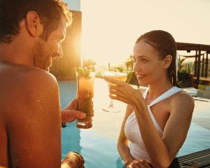 a man and woman drinking cocktails by the pool at Hotel Faro, a Lopesan Collection Hotel - Adults Only in Maspalomas