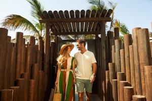 a man and a woman standing in front of a fence at Hotel Faro, a Lopesan Collection Hotel - Adults Only in Maspalomas