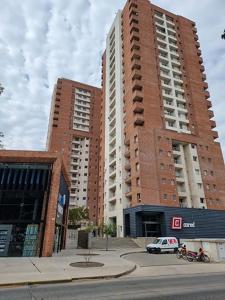 un edificio alto de ladrillo con un coche aparcado delante de él en Buena Vista en Río Cuarto