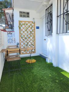 a patio with green grass and a wooden bench at "COZY LOFT", TERRACE, PARKING and SWIMMING POOL in Málaga