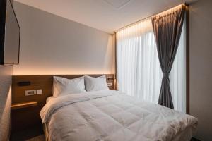 Postel nebo postele na pokoji v ubytování Pillowsopher Hongdae