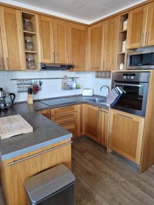 a kitchen with wooden cabinets and a stove top oven at Apartmán Rubicon in Poprad