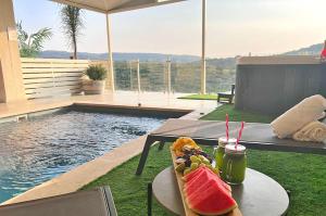a plate of food on a table next to a pool at סוויטות Sol - סוויטות מהממות בגליל עם בריכה וג'קוזי במתחם in Gornot HaGalil +11 photos