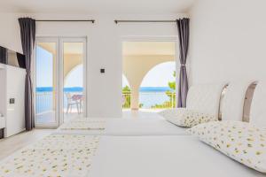 a bedroom with two beds and a balcony at Modern Beach Apartments - Swimming Pool in Marusici 