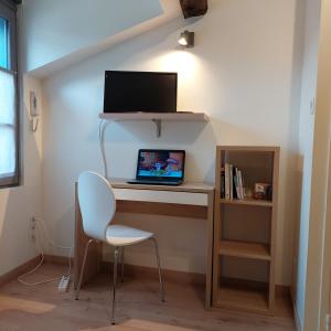 a desk with a laptop and a chair in a room at Appart face au mail in Limoges