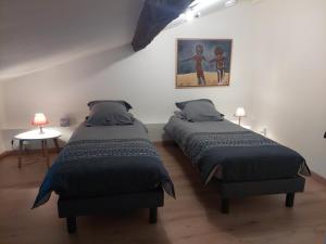 - une chambre avec 2 lits et une photo sur le mur dans l'établissement Appart face au mail, à Limoges