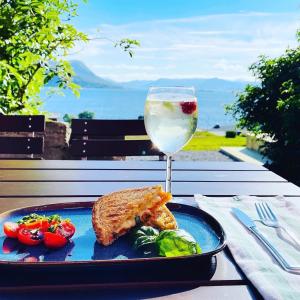 a blue plate of food and a glass of wine at Kråen Gard in Larsnes