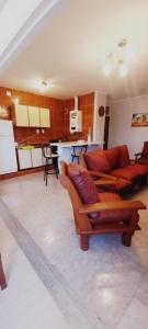 sala de estar con 2 sofás y cocina en Departamentos San Martin 2175 en Salta