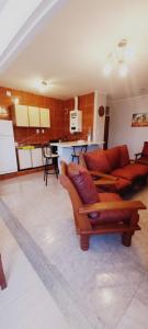 a living room with two couches and a kitchen at Departamentos San Martin 2175 in Salta