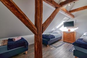 a attic room with two beds and a tv at Agroturystyka Sòjkowy Zakątek in Dzierżążno Małe