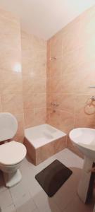 een badkamer met een bad, een toilet en een wastafel bij Departamentos San Martin 2175 in Salta