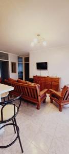 a living room with two benches and a flat screen tv at Departamentos San Martin 2175 in Salta