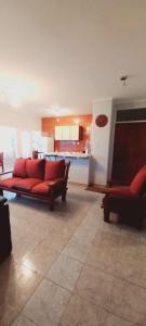a living room with red couches and a kitchen at Departamentos San Martin 2175 in Salta