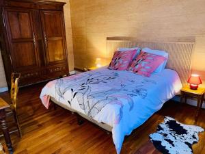 a bedroom with a bed with blue and pink pillows at Grand Messier 8 personnes in Senones +4 photos